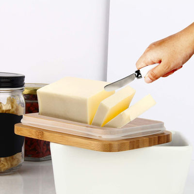 Piatto di burro ceramico bianco con il coperchio ed il coltello per il contatore di cucina