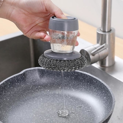 L'acciaio inossidabile pulisce gli impianti di lavaggio con una spugna della lana con l'erogatore del sapone