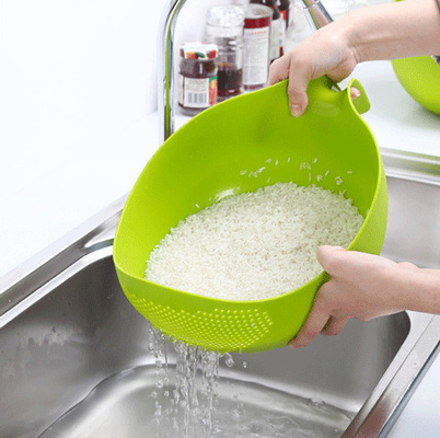 Ciotola di plastica del filtro del riso con la cucina della maniglia che vuota le colapaste per le verdure di pulizia