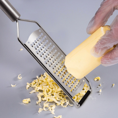 Grattugia di verdure tenuta in mano dell'affettatrice di acciaio inossidabile della taglierina di multi scopo